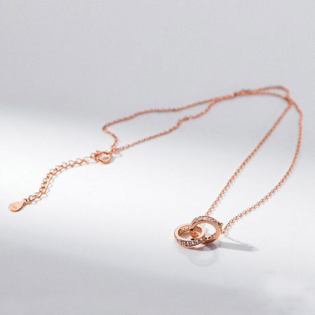 Elegant rose gold necklace with a sparkling interlocking circle pendant.