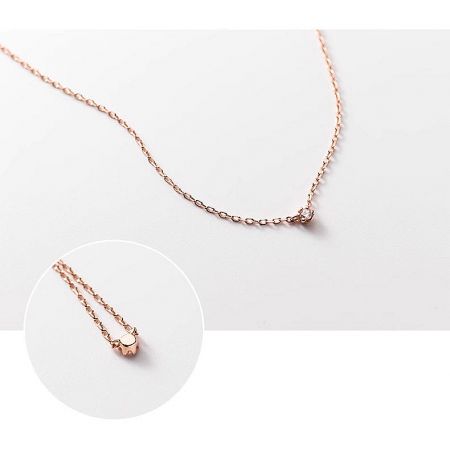 Angled shot of the delicate rose gold necklace with its CZ pendant.