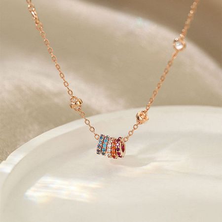 Full view of the rose gold necklace with multi-colored stone pendant.