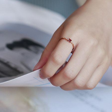 Close-up of the 925 Sterling Silver Ring in a rose gold finish, highlighting the vibrant red gemstone and two smaller white gems.