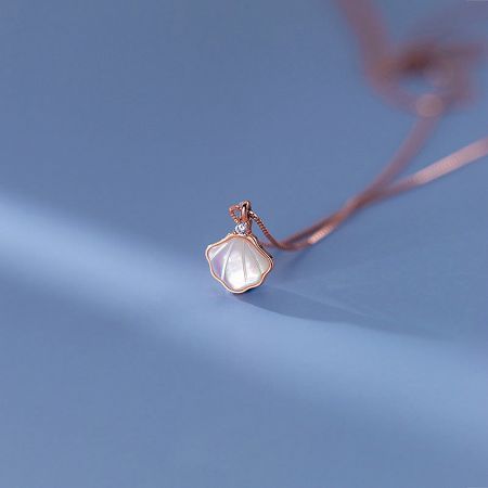 Close-up of the rose gold seashell mother of pearl pendant necklace.