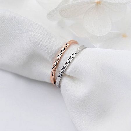 Detailed view of the zigzag pattern on the rose gold and silver stack rings.