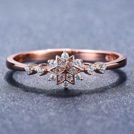 The Starlight Sparkle snowflake ring in a warm rose gold finish, adorned with sparkling diamonds.
