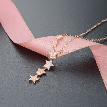 Detailed view of the rose gold star tassel necklace, highlighting its sparkling finish.