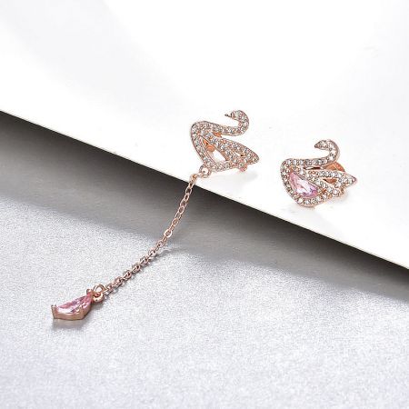 Detailed view of the rose gold swan earrings adorned with sparkling gemstones.
