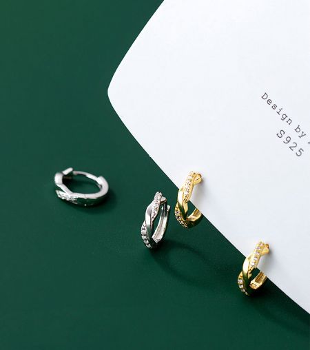 A display of the elegant twist earrings in both silver and gold, highlighting the S925 sterling silver quality.