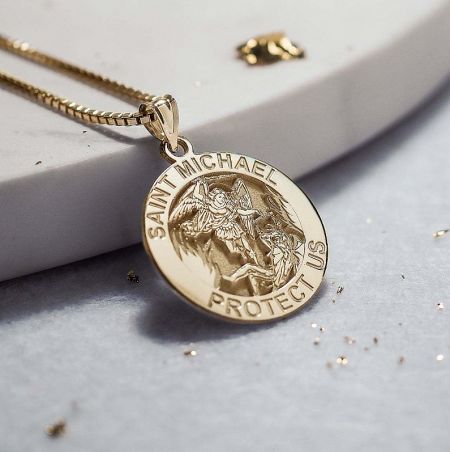 A gold pendant necklace depicting Saint Michael, a powerful symbol of protection.