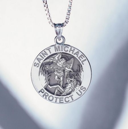 Detailed engraving on the Saint Michael pendant showing the defeat of a demon.