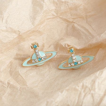 Close-up view of the gold-plated planet earring with light blue enamel and gemstone embellishments.