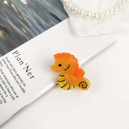Charming yellow seahorse-shaped hair clip.