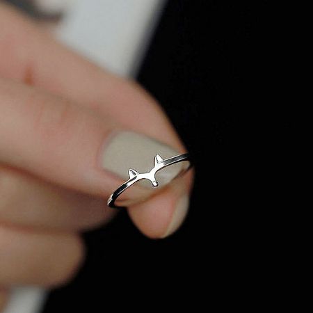 A playful sterling silver ring designed in the shape of an airplane.