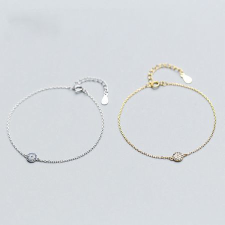 A pair of evil eye charm bracelets, one silver and one gold, displayed side-by-side.