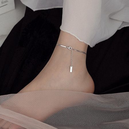Close-up of the 925 silver snake chain anklet on a model's ankle, paired with sandals.