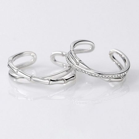 Detailed view of the bamboo-inspired silver rings, one plain and one with sparkling accents.