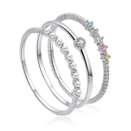 A close-up view of the three stackable rings, showing the detail of the rhodium plating and the colorful CZ stones.