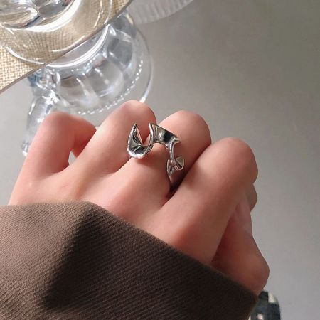 Brass Jewelry Wholesale Silver Adjustable Rings for Women Abstract Design Set of 5 - A woman's hand wearing one of the abstract silver-tone adjustable brass rings from the wholesale set of 5, featuring a unique wing-like design.