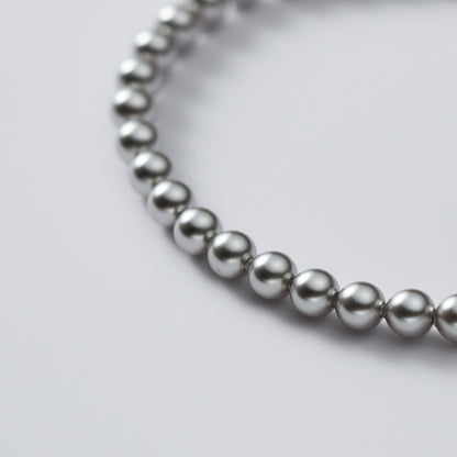 The versatile sterling silver pearl bracelet displayed in a coiled arrangement.