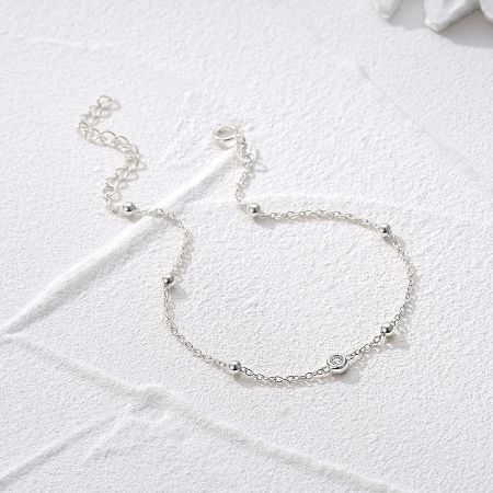 The silver bracelet showcasing its decorative beads and zircon accent.