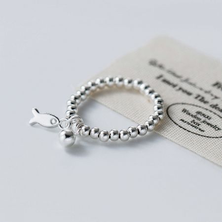 Detailed view of the 925 sterling silver beaded fish charm ring with a CZ ball accent.