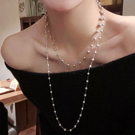 Set all'ingrosso di 5 gioielli in ottone con perle finte a doppio strato in stile coreano, dichiarazione di moda elegante. - Un modello che indossa l'elegante collana a doppio strato in perle finte in stile coreano, mostrando il suo design sofisticato.