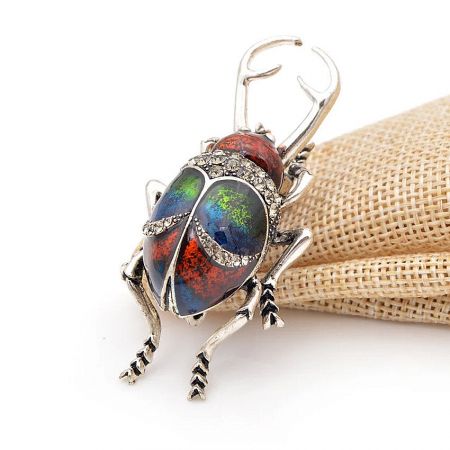 A variation of the beetle brooch with opal-like stones, demonstrating its versatility as a pendant.