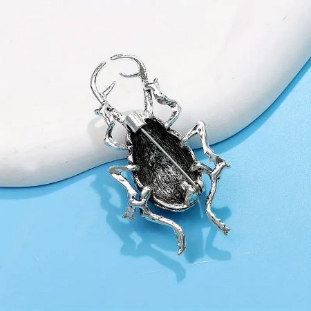 A silver and black version of the beetle brooch, suitable for various styles.