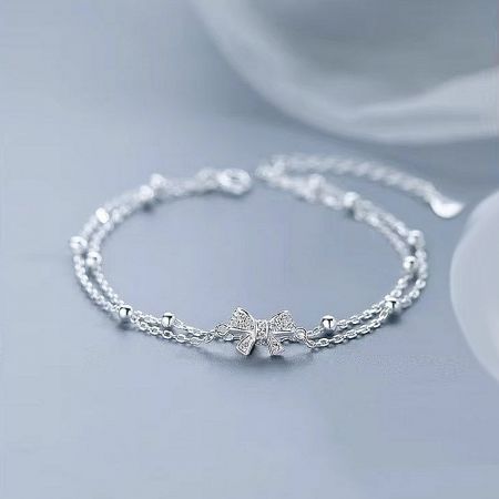 Product photo of the elegant silver bow bracelet, highlighting its polished finish.