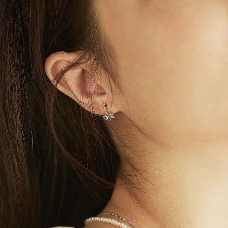 Sterling silver bow earring styled with a classic double-strand pearl necklace.