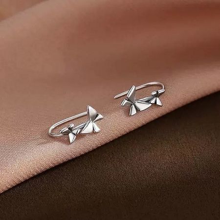 Close-up of delicate 925 silver bow-shaped earrings from the kawaii gift set.
