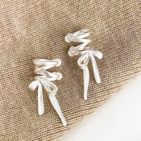 A pair of sterling silver bowknot ear cuffs with elegant long tails.