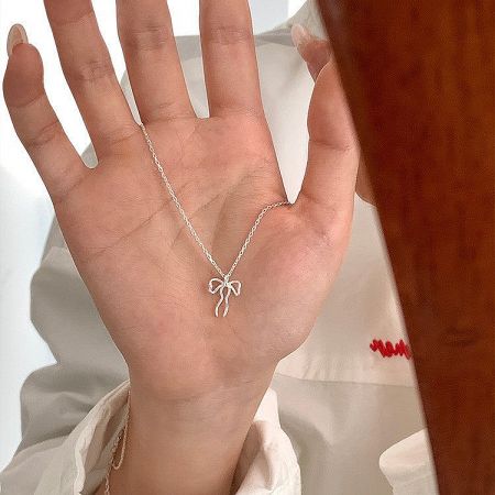 Full view of the 925 sterling silver bow pendant necklace on a neutral background.