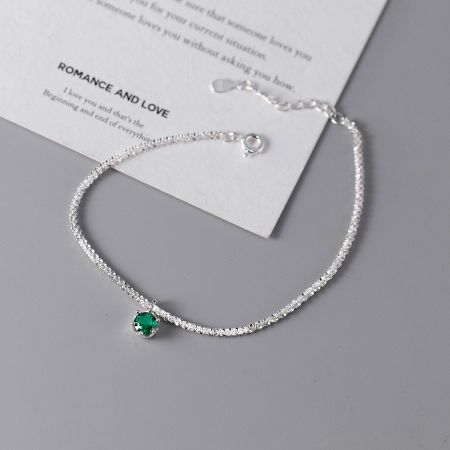 The minimalist starry bracelet showcasing the vibrant green zircon gemstone.