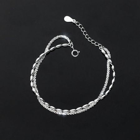 Detailed close-up of a sterling silver bracelet featuring intertwined chains with oval and round links.