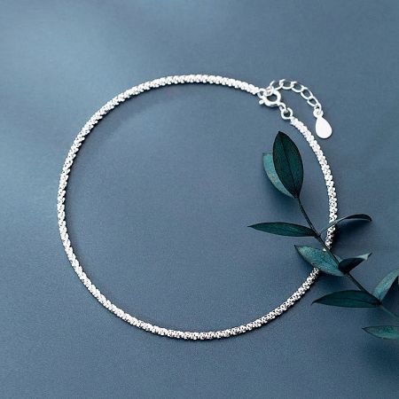 Detail of the bracelet's clasp and teardrop charm.