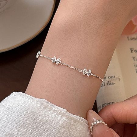 A delicate 925 sterling silver butterfly bracelet worn on a wrist.