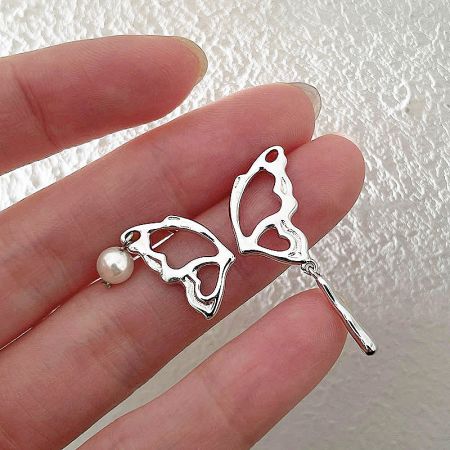 Detailed shot of the 925 sterling silver butterfly earring with a single pearl.