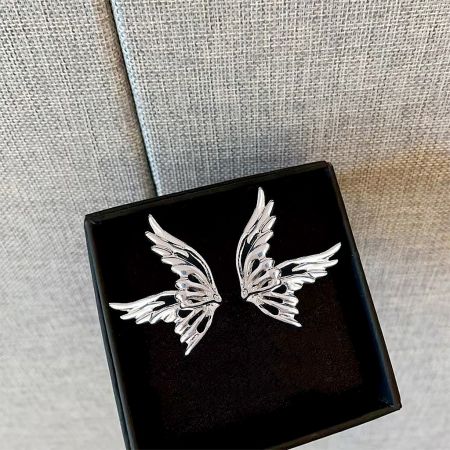 The set of silver-plated butterfly stud earrings presented in a stylish black jewelry box.