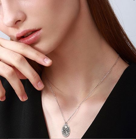 Model wearing a custom religious pendant necklace, showcasing its size and style.