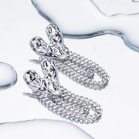 Close-up of a stylish silver chain earring with an abstract top piece.