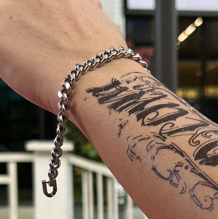 Side view of the stainless steel Cuban link bracelet on a wrist, showing the detail of the chain.