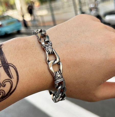 A man wearing the stylish silver chain Chunky Cuban Bracelet to showcase its fit and appearance.