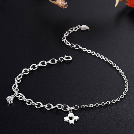 A charming silver chain bracelet adorned with both flower and heart charms.