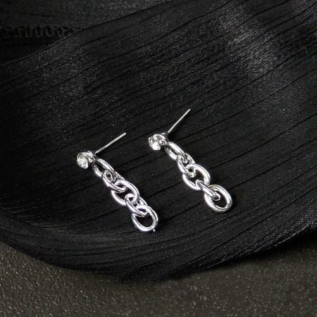 A pair of silver-plated chain link drop earrings with zircon pendants against a white backdrop.