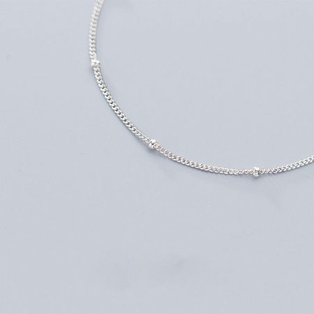 Detailed view of the delicate beads on the silver chain bracelet.
