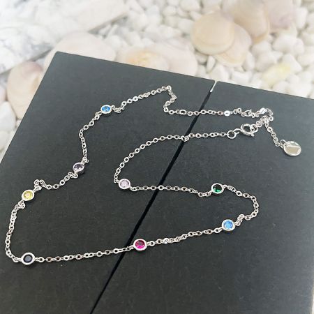 Close-up shot of the delicate silver chain and vibrant multicolored CZ stone charm.