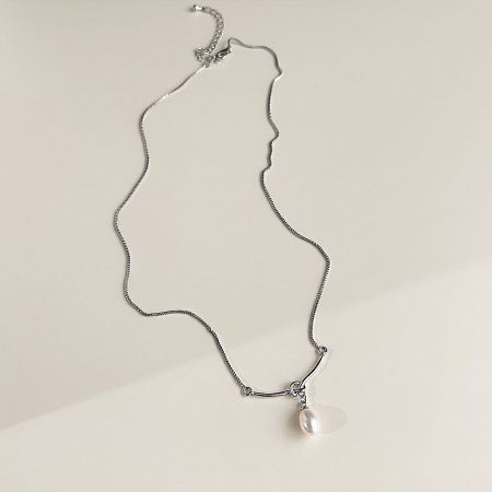 Front view of the silver chain necklace featuring a classic white pearl pendant.