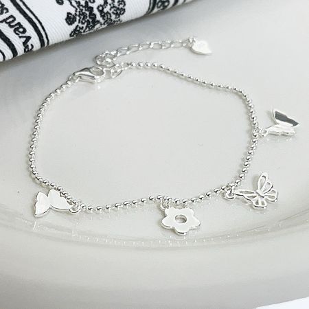 The 925 sterling silver bracelet with its nature-themed charms laid flat for a full view.