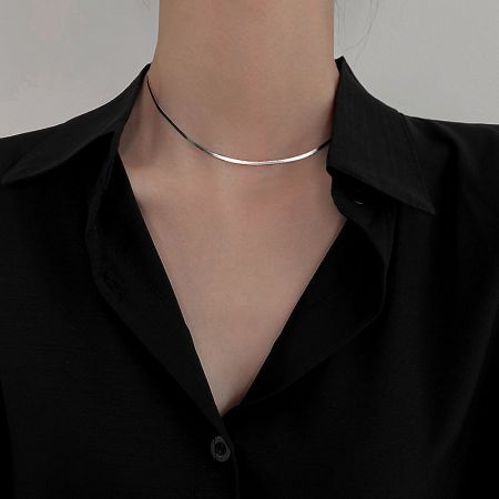 The sterling silver herringbone necklace styled as a choker, demonstrating its versatility.