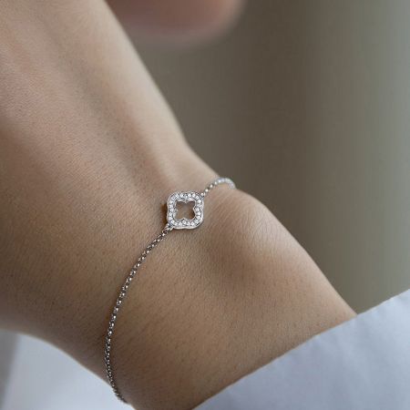 A model wearing the 925 sterling silver lucky clover bracelet with CZ stones on her wrist.