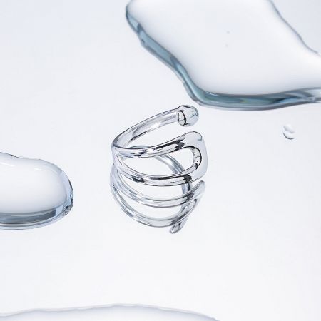 A modern stainless steel ring featuring a sleek coil shape.